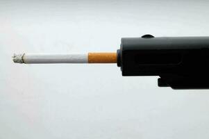 ein Zigarette ist stecken im das Ende von ein Gewehr foto
