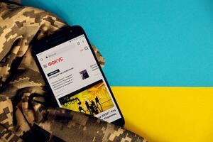 Kiew, Ukraine - - 4 dürfen, 2023 Fokus ukrainisch Nachrichten Portal auf Smartphone Bildschirm mit ukrainisch Flagge und tarnen Stoff foto