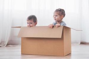 zwei kleine Kinder, Junge und Mädchen, sind gerade in ein neues Zuhause gezogen. Konzeptfoto .. Kinder haben Spaß. foto