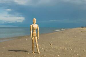 hölzern Modelle Gefühl einsam auf das Strand. foto