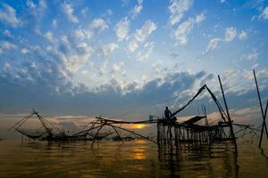 Angeln Ausrüstung mit Sonnenaufgang beim pakpra ,phatthalung,thailand foto