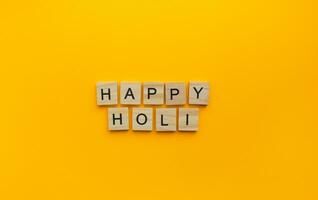 auf März 8, holi ist ein Feier von Frühling und hell Farben im Indien, ein minimalistisch Banner mit ein Inschrift im hölzern Briefe foto