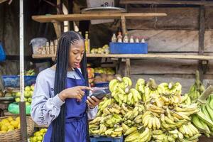 afrikanisch Markt Frau halten ein pos Gerät foto