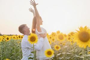 schönes paar, das spaß in sonnenblumenfeldern hat foto