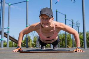 sportliche Frau, die an sonnigen Sommertagen auf dem Sportplatz trainiert foto