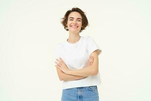 Porträt von heiter Frau Lachen und lächelnd, Kreuz Waffen auf Brust, Stehen im zuversichtlich Leistung Pose, jung Fachmann Konzept, Weiß Studio Hintergrund foto