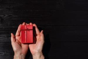 Blick von oben auf die Hand der Frau geben Geschenkbox zu Weihnachten foto