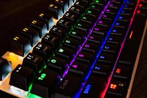 mehrfarbige professionelle Gaming-mechanische RGB-Tastatur auf dem Tisch foto
