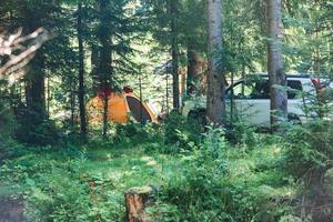 gelbes Zelt mit Geländewagen im Wald foto