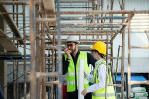 Ingenieur und Architekt Arbeiten auf das Konstruktion Grundstück, doppelt prüfen Pläne und Verfahren. foto