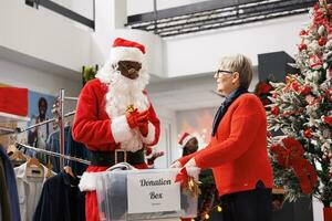 Menschen Füllung aus Kisten zum Geschenke zu helfen Santa claus Arbeiter verteilen Weihnachten Geist und spenden zu Wohltätigkeitsorganisationen. Urlaub Großzügigkeit beinhaltet Erwachsene Sammeln Kleider zum Kinder im brauchen. foto