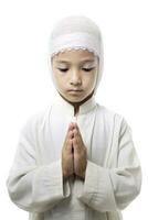 ai generiert ein Junge im ein Weiß Kleid Hemd und Hut, beten mit umklammert Hände. foto