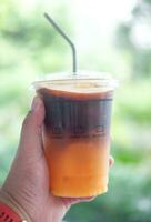 kalt vereist schwarz brauen Kaffee gemischt Orange Saft, frisch Sommer- trinken im das Morgen foto