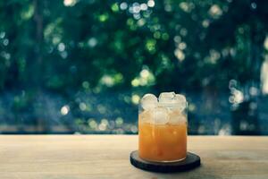 ein Glas von Orange Saft mit Eis auf Holz Tabelle foto