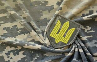 Symbol von ukrainisch Heer auf das tarnen Uniform von ein ukrainisch Soldat. das Konzept von Krieg im Ukraine, Patriotismus und schützen Ihre Land von Besatzer foto