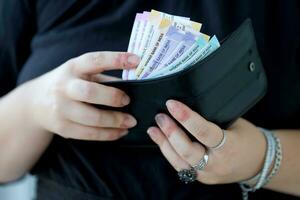 Frau Hand mit indisch Rupien Rechnungen. Konzept von finanziell Operationen im Kasse im Indien foto