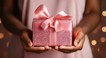 ai generiert ein glücklich Geburtstag Geschenk eingewickelt im Rosa Band ist gehaltenen im das Hände von Personen foto