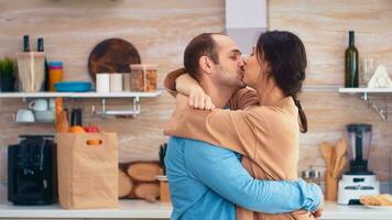 charmant verheiratet Paar voll von Glück Tanzen im Küche. heiter glücklich jung Familie zusammen tanzen. Spaß Liebe Zuneigung Romantik Freizeit romantisch Musik- zum Genuss foto