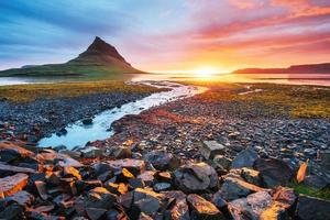 der malerische Sonnenuntergang über Landschaften und Wasserfällen. Kirkjufell-Berg. Island