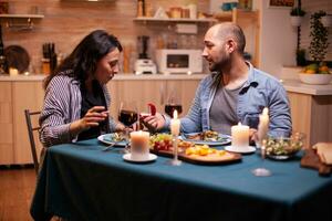 Frau überrascht durch Ehe Vorschlag von Mann während romantisch Abendessen. Küche während romantisch Abendessen. glücklich kaukasisch Frau lächelnd Sein sprachlos foto