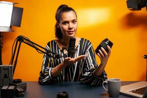 präsentieren und testen Kamera Linse während vlog im Zuhause Studio. Neu Medien Star Influencer auf Sozial Medien reden Video Foto Ausrüstung zum online Internet Netz zeigen.