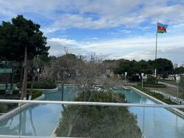 ai generiert Park mit Schwimmbad und Aserbaidschan Flagge winken im wolkig Wetter foto