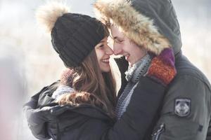 fröhliches junges Paar, das Spaß im Winterpark hat foto