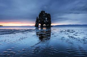 hvitserkur ist ein spektakulärer Felsen im Meer an der Nordküste Islands. Legenden sagen, es sei ein versteinerter Troll. Auf diesem Foto spiegelt sich die Hvitserkur nach dem Mitternachtssonnenuntergang im Meerwasser