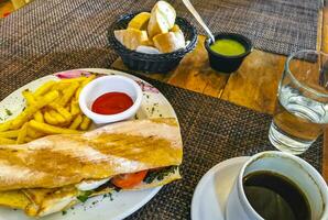 Stangenbrot Sandwich Toast Brot mit Hähnchen Tomate Salat Kartoffeln Fritten. foto