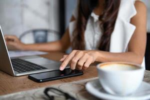 weibliche Geschäftsleute verwenden Smartphone und Laptop, um im Büro zu arbeiten. foto