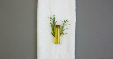 Rosmarin Öl auf ein Weiß Handtuch. natürlich Kosmetika zum Körper und Haar Pflege. foto