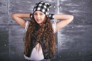 junges schönes Mädchen tanzt in trendiger Kleidung auf Grunge-Hintergrund