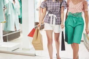 Frauen, die beim Einkaufen im Einkaufszentrum mit Taschen gehen foto