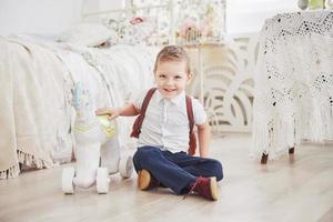 süßer kleiner Junge geht zum ersten Mal zur Schule. Kind mit Schultasche und Buch. Kind macht eine Aktentasche, Kinderzimmer auf einem Hintergrund. zurück zur Schule foto