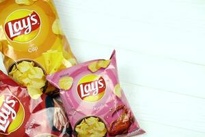 charkow, ukraine - 3. januar 2021 verschiedene aromatisierte kartoffelchips von laien auf holzhintergrund. Lay's war 1965 über Frito-Lay im Besitz von Pepsico foto