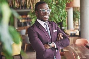 glückliches Lächeln eines erfolgreichen afroamerikanischen Geschäftsmannes im Anzug