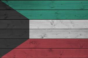 Kuwait Flagge abgebildet im hell Farbe Farben auf alt hölzern Mauer. texturiert Banner auf Rau Hintergrund foto