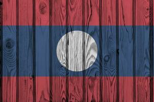 Laos Flagge abgebildet im hell Farbe Farben auf alt hölzern Mauer. texturiert Banner auf Rau Hintergrund foto