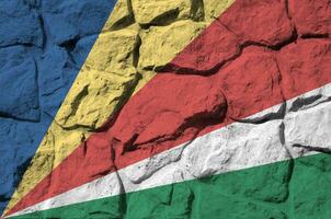 Seychellen Flagge abgebildet im Farbe Farben auf alt Stein Mauer Nahaufnahme. texturiert Banner auf Felsen Mauer Hintergrund foto