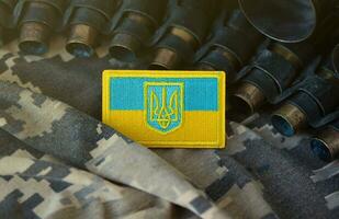 ukrainisch Symbol auf Maschine Gewehr Gürtel Lügen auf ukrainisch pixelig Militär- tarnen foto