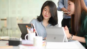 Ein Team von professionellen Designern arbeitet mit Smartphones und Laptops, um Anwendungen zu entwerfen. foto