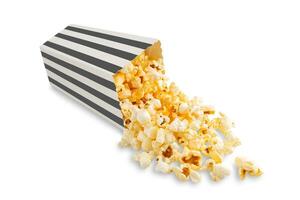 lecker Käse Popcorn fallen aus von ein schwarz gestreift Karton Eimer, isoliert auf Weiß Hintergrund foto