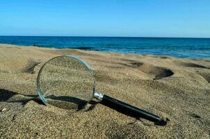 Vergrößerung Glas auf das Strand foto