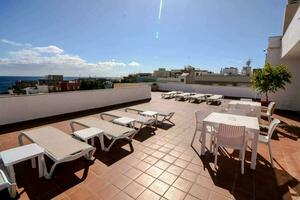 ein Dach Terrasse mit Weiß Stühle und Tabellen foto