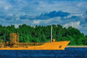 Gelb Ladung Tanker Schiff ziehen um beim das klar Sommer- Tag foto