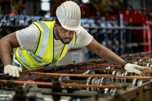 afrikanisch amerikanisch industriell Arbeiter ist Überprüfung das Konfiguration Wert von Metall Blatt rollen Bildung Maschine Innerhalb Dach Fabrik zum Sicherheit Industrie Konstruktion foto