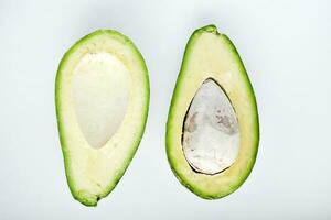 Avocado Obst Schnitt im Hälfte auf ein Weiß Hintergrund. Grün Früchte sind zum Vegetarier. köstlich Diät Lebensmittel. foto