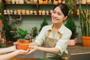 Porträt von asiatisch Frau Arbeiten im ein Pflanze Geschäft foto