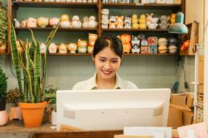 Porträt von asiatisch Frau Arbeiten im ein Pflanze Geschäft foto