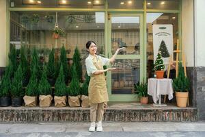 Porträt von asiatisch Frau Arbeiten im ein Pflanze Geschäft foto